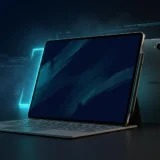 Galaxy Tab S12 Ultra with S Pen on a dark desk, AMOLED screen lit with cyan reflection