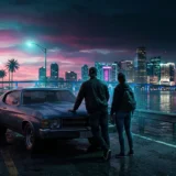 Couple seen from behind at dusk on a tropical beach with skyscrapers behind them and a pink and blue sky