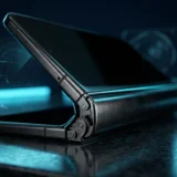 Half-open foldable smartphone on a dark surface reflecting cyan light off the metal hinge